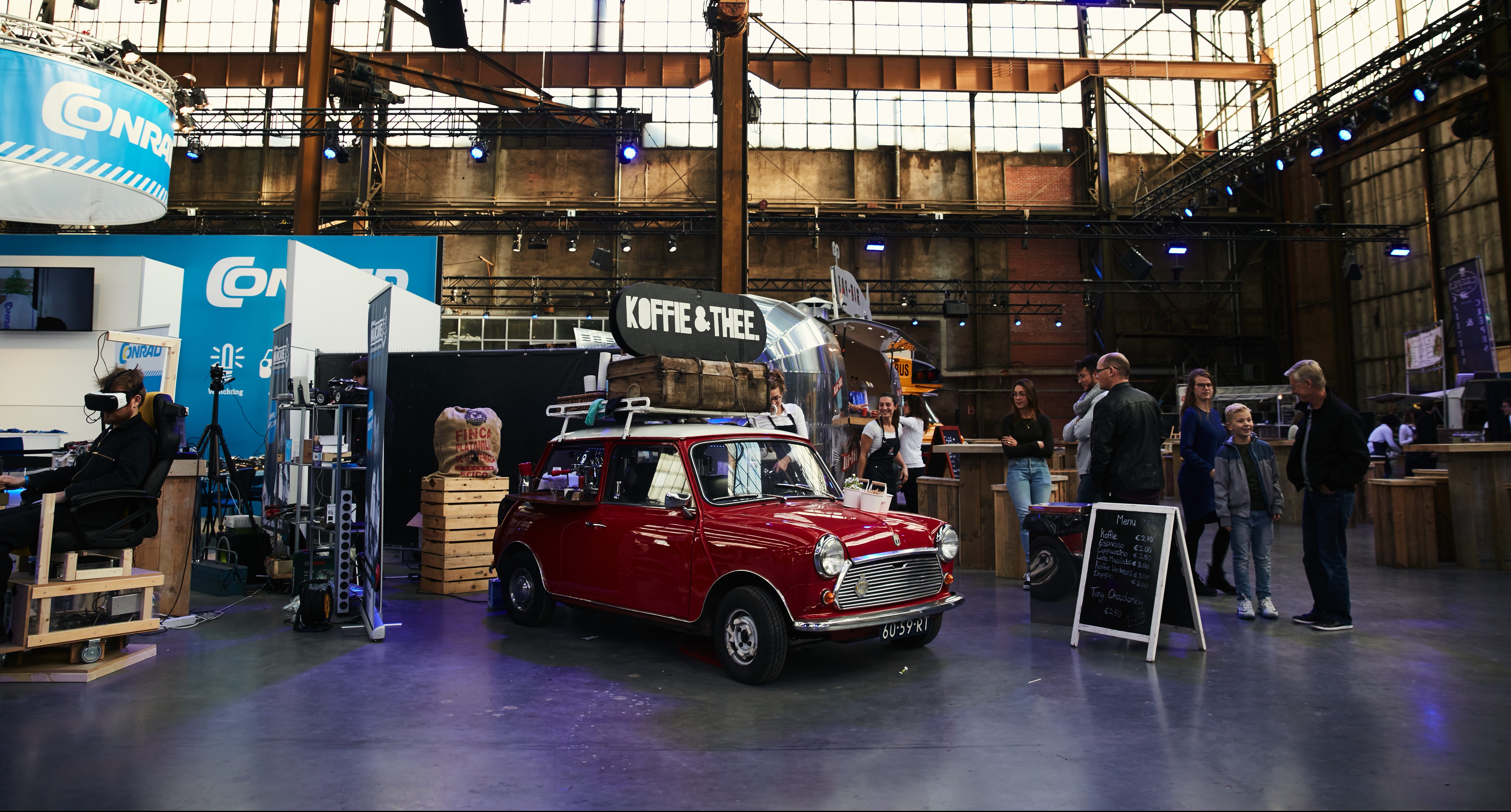 Onze mini cooper espressobar staat op een event waar een barista verse koffie maakt