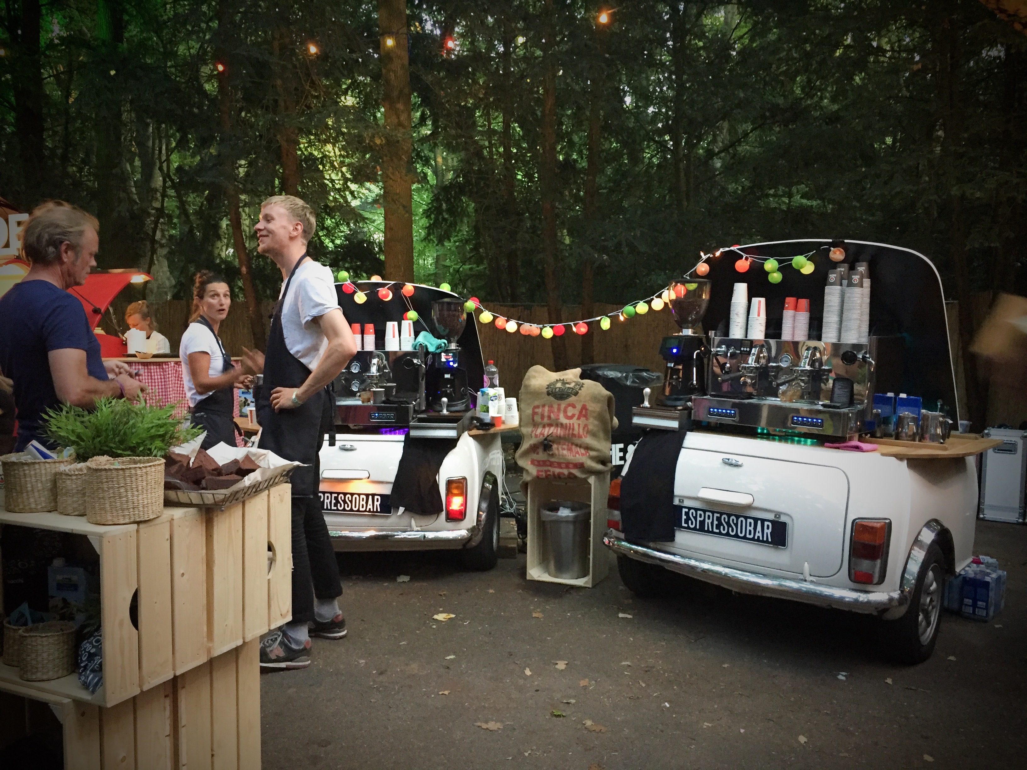 Een tweetal espressobars met een barista op een festival