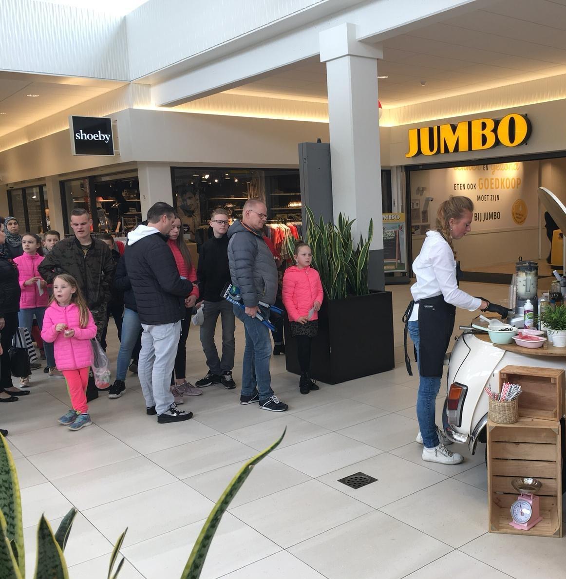 Voor de supermarkt maakt een personeelslid smoothies aan onze mobiele smoothiebar